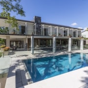 Perfect for entertaining on a grand scale, this apartment, condominium, elevation, estate, facade, home, house, property, real estate, residential area, resort, swimming pool, villa, teal