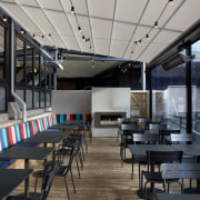 An outdoor fireplace is a feature of the café, interior design, restaurant, black, gray