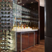 Adjacent to the kitchen in this apartment is glass, interior design, liquor store, wine cellar, winery, black