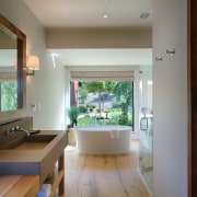 This bathroom shows the more contemporary feel that architecture, ceiling, daylighting, floor, flooring, hardwood, home, house, interior design, living room, real estate, room, window, wood flooring, gray, brown