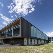 Wood soffits add a natural accent to the architecture, building, commercial building, corporate headquarters, facade, headquarters, mixed use, real estate, sky, teal
