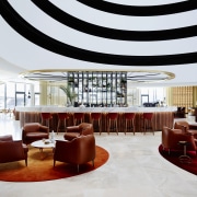 A curvaceous bar area provides the social focal ceiling, function hall, interior design, lobby, restaurant, table, white