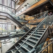 The central atrium of 2 Graham St by architecture, building, handrail, mixed use, stairs, black, white