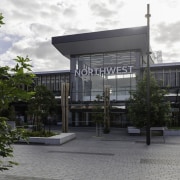 A double-height, glass fronted atrium provides the high-profile architecture, building, commercial building, condominium, corporate headquarters, facade, mixed use, real estate, tree, gray