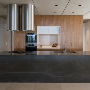 A benchtop pocket slider can screen off the architecture, ceiling, countertop, floor, flooring, interior design, kitchen, laminate flooring, lobby, real estate, wood flooring, gray, black