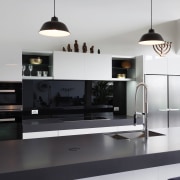 This kitchen in a warehouse conversion presents as countertop, furniture, interior design, kitchen, product design, white, black