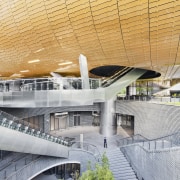 Lower level retail provides direct access to the architecture, building, convention center, corporate headquarters, daylighting, daytime, headquarters, line, metropolis, metropolitan area, mixed use, sport venue, structure, urban area, orange, gray