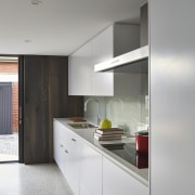 This white kitchen with glass splashback is positioned architecture, cabinetry, countertop, interior design, kitchen, real estate, gray