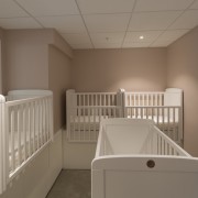 The sleeping room for infants enrolled at Cosmokids ceiling, floor, furniture, home, product, room, window, brown, gray