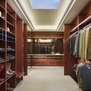 With no windows, this large closet is the bookcase, cabinetry, ceiling, closet, flooring, furniture, interior design, lobby, room, wardrobe, red, gray