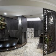 Stone, porcelain, bronze and natural wood combine to ceiling, interior design, lobby, room, gray, black