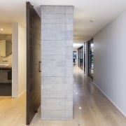 This textured concrete dividing wall has a pivot apartment, architecture, floor, flooring, home, house, interior design, loft, real estate, wood, wood flooring, gray, white