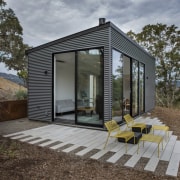 This fully self-contained guest house sits away from backyard, cottage, home, house, outdoor structure, real estate, shed, gray, brown