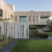 The stone blades protruding from the cladding create apartment, architecture, backyard, building, courtyard, estate, facade, grass, home, house, interior design, land lot, lawn, property, real estate, residential area, roof, room, tree, urban design, villa, yard, gray, brown