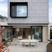 The rear façade features cement-sheet cladding with semi-random 