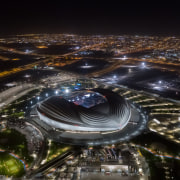The dramatic Al Janoub Stadium by night. - aerial photography, architecture, arena, bird's-eye view, city, cityscape, human settlement, landscape, metropolis, metropolitan area, night, photography, sky, skyscraper, soccer-specific stadium, space, sport venue, stadium, urban area, water, black