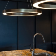 Two hand crafted, aged bronze pendant lights appear 