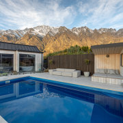 Sheltered poolside seating with sauna at right. 