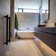 The textured wall behind the tub gives the 