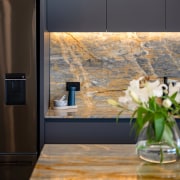 The stone benchtop and splashback give the kitchen 