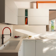 The bright-orange cooker hood ducting and kitchen tap 