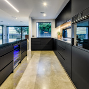 Stained concrete provides a solid anchor for this architecture, building, ceiling, countertop, design, floor, flooring, furniture, glass, home, house, interior design, lighting, office, property, real estate, room, black, gray