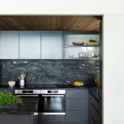 The stone-look splashback echoes the tones of the 