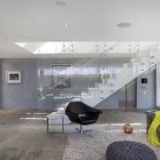 The first floor of this beachhouse accommodates a apartment, architecture, ceiling, daylighting, floor, house, interior design, living room, lobby, real estate, gray