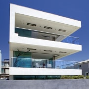 The white, cantilevered forms of this beachside house architecture, building, commercial building, corporate headquarters, elevation, facade, house, real estate, sky, blue