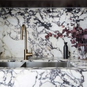 The dark cabinetry connects with the dark veining 