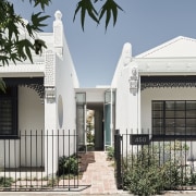 A glazed entry, set back between the heritage white