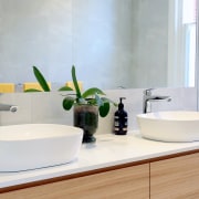 The contemporary design for this bathroom included tabletop architecture, bathroom, bathroom accessory, bathroom cabinet, bathroom sink, ceramic, countertop, floor, flooring, furniture, interior design, material property, plumbing fixture, product, property, room, sink, tap, tile, wall, white, white, gray