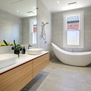 We redesigned the floor plan to include a architecture, bathroom, bathtub, building, ceiling, floor, flooring, furniture, home, house, interior design, material property, plumbing fixture, property, real estate, room, sink, tap, tile, wall, gray