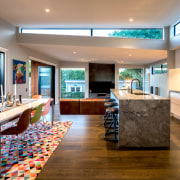 A pop-up roof over the kitchen/dining space provides architecture, building, cabinetry, ceiling, countertop, design, floor, flooring, furniture, hardwood, home, house, interior design, kitchen, lighting, living room, property, real estate, room, table, wood flooring, gray