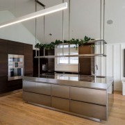 Hanging/suspended shelves above the island complement the slope cabinetry, countertop, floor, furniture, interior design, kitchen, gray