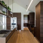 The open plan has a good flow to architecture, cabinetry, countertop, floor, flooring, hardwood, house, interior design, kitchen, real estate, wood, wood flooring, black, gray