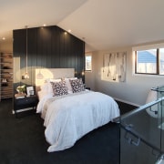 A floor-to-ceiling bedhead separates bedroom from dressing area. 