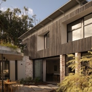 Courtyard with timber cladding rising behind. 