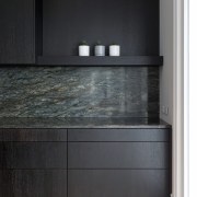 The Fusion granite benchtops turn seamlessly up the 