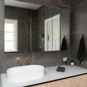 The vanity's warm timber tones accent the concrete 