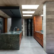 The timeless kitchen is naturally lit with a architecture, building, ceiling, concrete, floor, flooring, furniture, home, house, interior design, lobby, loft, property, room, space, tile, wall, gray, taps, tapware