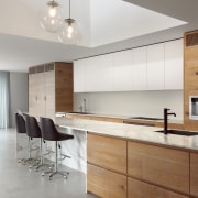 Porcelain tile flooring grounds the arresting, material-rich kitchen. 