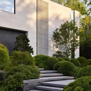 The home's stepped approach is edged in shrubbery. 