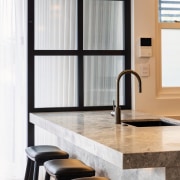 The chunky stone island benchtop overhang provides an 