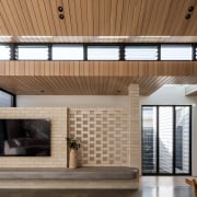 Perforated brick wall, timber ceiling and television. 