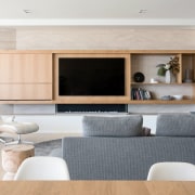 Custom built-in cabinetry accommodates the television in this building, cabinetry, ceiling, coffee table, couch, design, fireplace, floor, flooring, furniture, hardwood, home, house, interior design, living room, property, real estate, room, table, wall, wood flooring, gray
