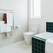 Large format white wall and floor tiles provide 