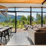 A geometric-style pendant hovers over the wood-topped dining 