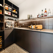 The scullery continues the cabinetry tones of the 