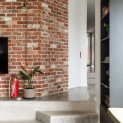 Inside, reclaimed brickwork, polished concrete and black joinery 